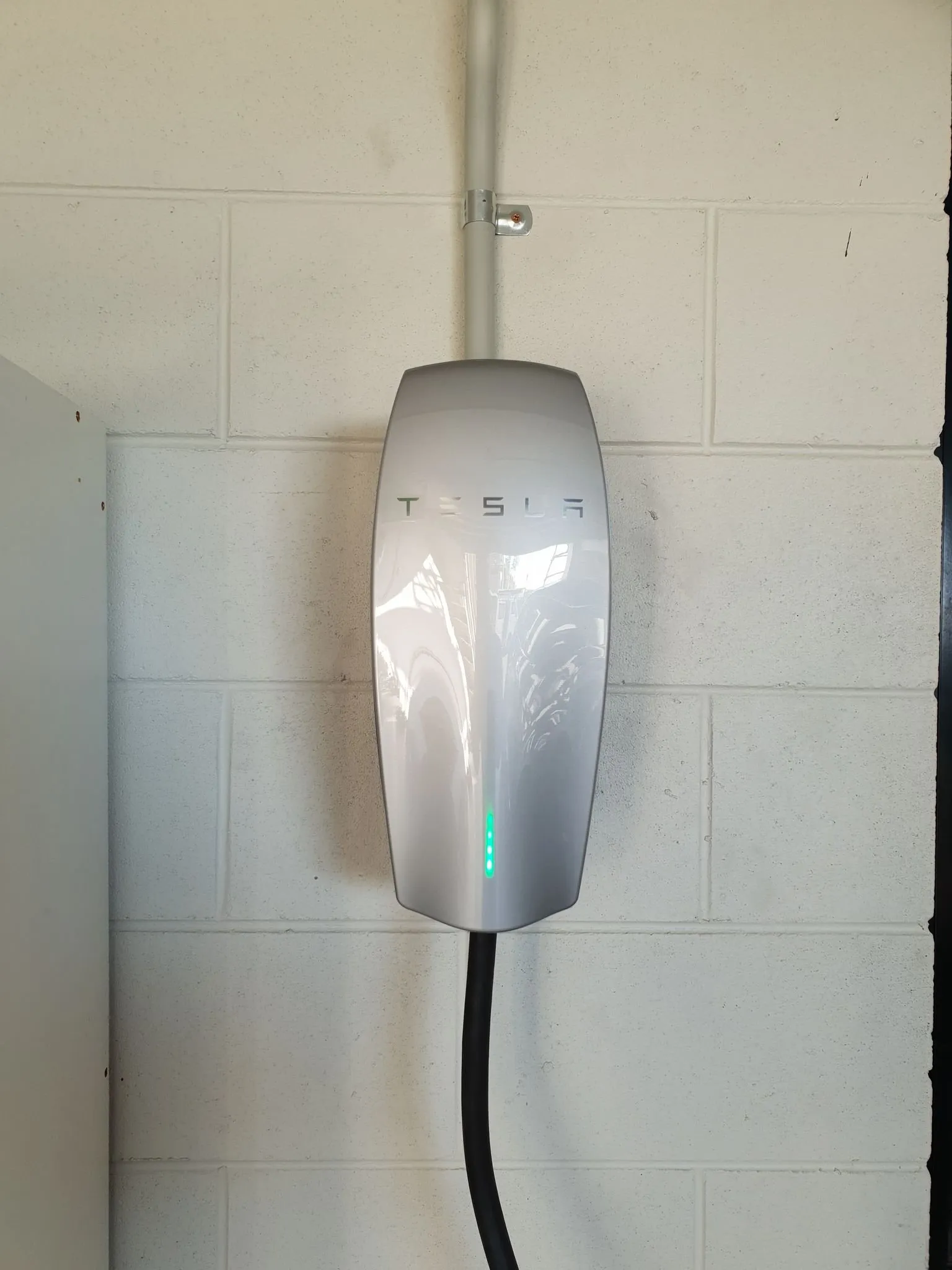 Tesla wall connector EV charger installed by On Point Solar & Electrical in a Townsville garage